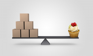Photo of wooden blocks balanced against a cupcake on a wooden plank
