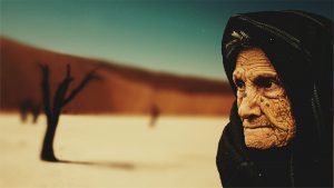 Image of an old, wrinkled woman in the desert