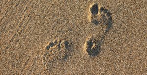 Earthing - Image of footprints in the sand