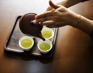 Gingivitis - Image of a woman's hands pouring green tea