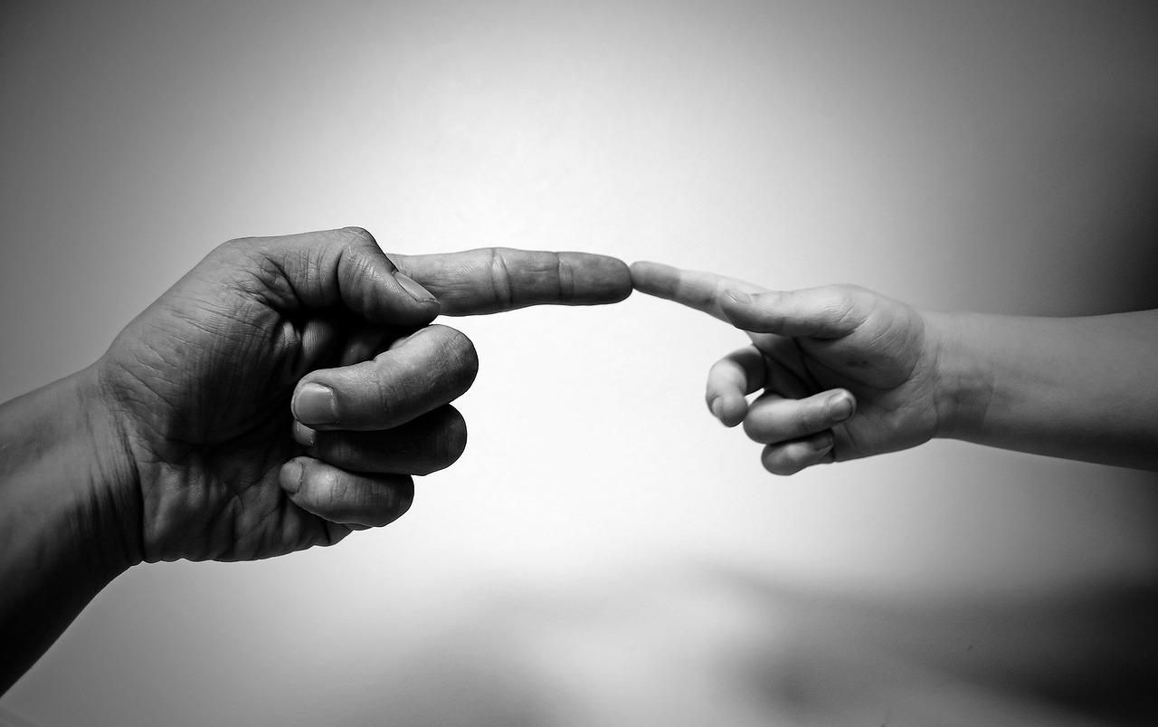 Image of Adult finger touching child finger