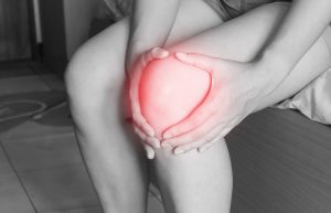 Woman clutching inflamed knee